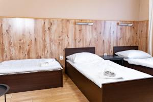 dwa łóżka w pokoju z drewnianymi ścianami w obiekcie Hotel Taurus w Ostravie +37 zdjęć
