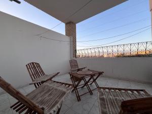 a room with two chairs and a balcony at Dar Beya ( APP S+2 ) in Tozeur