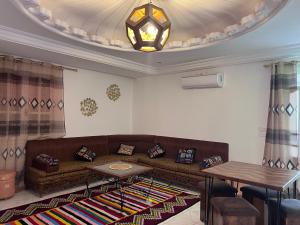 a living room with a couch and a table at Dar Beya ( APP S+2 ) in Tozeur