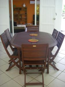 a wooden table with chairs and a dining room at Villa Du Lagon in La Saline les Bains