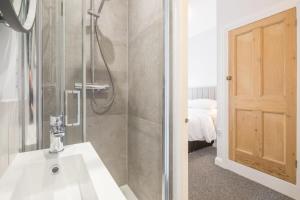 een badkamer met een wastafel en een douche bij Central 4 Bed Home With Parking in Cambridge