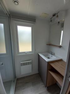 a bathroom with a sink and a window at mobilhome 6/8 personnes in La Tremblade
