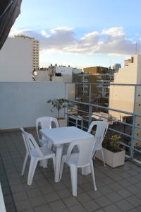 una mesa blanca y sillas sentadas en el techo en Le Batiment Apartmentos en Buenos Aires