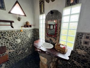 y baño con lavabo y espejo. en Orangutan Orchard Bungalow, en Timbanglawang