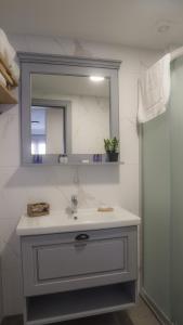 uma casa de banho branca com um lavatório e um espelho em Laika konukevi em Seferihisar