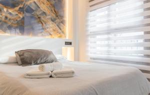 1 dormitorio con 2 toallas en una cama con ventana en Apartamento para dos al lado de la Alhambra, en pleno centro, en Granada