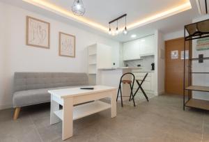 - un salon avec une table blanche et un canapé dans l'établissement Apartamento para dos al lado de la Alhambra, en pleno centro, à Grenade