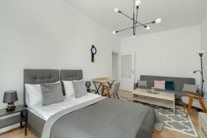 a bedroom with a large bed and a living room at Cosy Studio in the Centre of Poznań with Balcony by Renters in Poznań