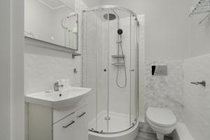 a bathroom with a shower and a sink and a toilet at Cosy Studio in the Centre of Poznań with Balcony by Renters in Poznań