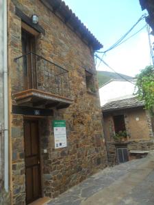 a building with a balcony on the side of it at La Jelechera in El Gasco