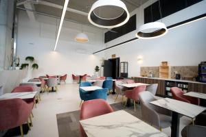 a restaurant with tables and chairs in a room at Arrow Hôtel in Hégenheim