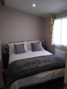 um quarto com uma cama grande e 2 almofadas em 3 Beds Sleeps 8 House Near California Cliffs Park em Norwich