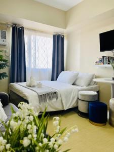 um quarto com uma cama com cortinas azuis e flores em City Hub Studio Unit with FAST Wifi, Netflix at Aspira Tower 1 em Cagayan de Oro
