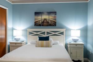 a bedroom with a white bed with two nightstands and two lamps at Marlin at the Lake - Downtown Sandusky in Sandusky