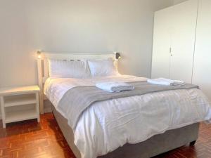 سرير أو أسرّة في غرفة في Lock up & go apt w/ great views in Simons Town