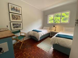 Lock up & go apt w/ great views in Simons Town في كيب تاون: غرفة نوم بسريرين ومكتب ونافذة