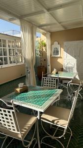 patio con tavolo e sedie sotto il portico di Riad Zeitoun Palace a Marrakech