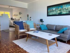 a living room with a couch and a table at Lock up & go apt w/ great views in Simons Town in Cape Town
