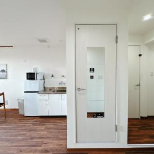 a kitchen with white cabinets and a glass door at 【三米通天閣】401-4FA難波商圈天王寺心斎橋10min in Osaka