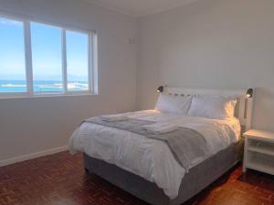 سرير أو أسرّة في غرفة في Lock up & go apt w/ great views in Simons Town