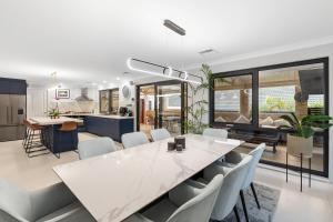 KinrossLuxury 5br villa with pool的厨房和餐厅配有白色桌子和椅子