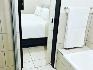 a small bathroom with a bed and a mirror at Luxurious Exclusive Home In A Golf Estate in Roodepoort