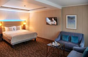 a hotel room with a bed and a couch at Olympus Hotel in Kaunas