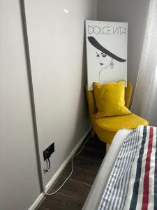 a bedroom with a mirror and a yellow chair at 2 Bed Home in Luton