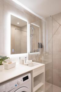 a bathroom with a sink and a washing machine at Vienna Heights Premium Apartments in Vienna +129 photos