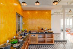 een grote keuken met houten kasten en werkbladen bij Bedzzz Xclusiv Morjim, Goa By Leisure Hotels in Morjim