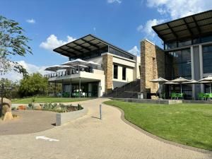a large building with a pathway in front of it at Luxurious Exclusive Home In A Golf Estate in Roodepoort