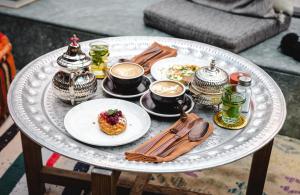 a table with plates of food and cups of coffee at CERVO Mountain Resort in Zermatt