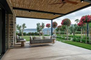 un patio con sofás en una terraza de madera en Palaia Hotel Datça en Datca