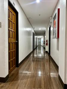 a hallway with a door and a long hallway with wooden floors at Island Wanderers Inn in Coron