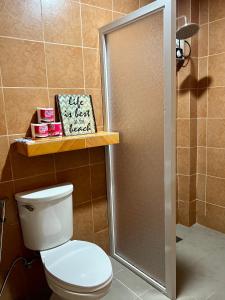 a bathroom with a toilet and a shower stall at Island Wanderers Inn in Coron