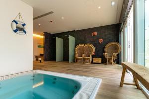 uma banheira de hidromassagem no meio de uma sala com cadeiras em La Réserve Comporta em Carvalhal