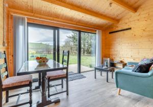 comedor con mesa de cristal y ventana grande en Foxglove Cabin, en Devils Bridge