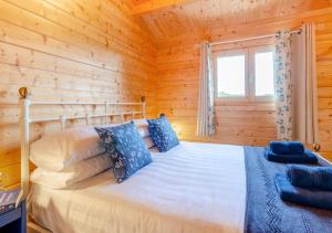 a bedroom with a bed in a wooden cabin at Bluebell Cabin in Devils Bridge