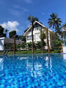 a large swimming pool in front of a house at Brooke Forest Heaven Resort in Vythiri