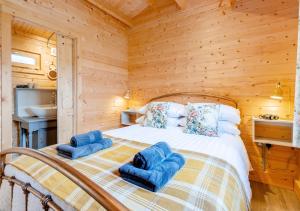 a bedroom with a bed with blue towels on it at Rose Cabin in Devils Bridge