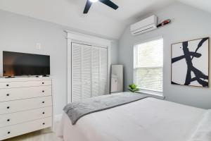 a white bedroom with a bed and a dresser at Modern Houston Hideaway with Balcony 2 Mi to Dtwn! in Houston