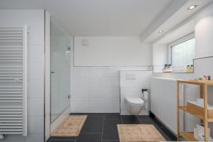 La salle de bains est pourvue d'une douche et de toilettes. dans l'établissement Entspannung im Boho-Flair: Sauna & Whirlpool, à Schwerte