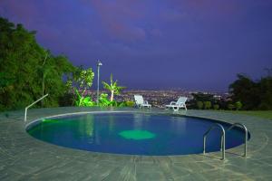 - une piscine entourée de 2 chaises la nuit dans l'établissement CASA CAMPESTRE LA PRADERA, à Cali