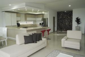 ein Wohnzimmer mit einem weißen Sofa und einer Küche in der Unterkunft CASA CAMPESTRE LA PRADERA in Cali