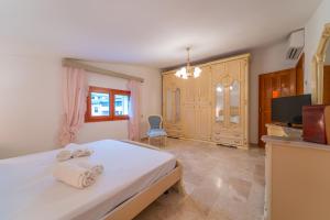 a bedroom with a white bed and a tv at Brorent Domo de Aurora in Olbia