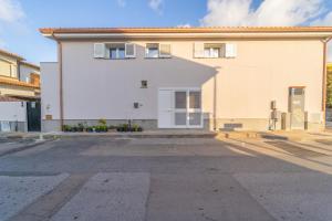 an empty parking lot in front of a white house at Brorent Domo de Aurora in Olbia