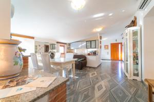 a kitchen and living room with a table and chairs at Brorent Domo de Aurora in Olbia