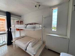 two bunk beds in a room with a window at ESTUDIO DOS PLAYAS LA MANGA in Murcia