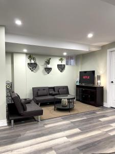 a living room with a couch and a tv at Niagara Falls BNB 15 mins away from Falls in Thorold +21 photos