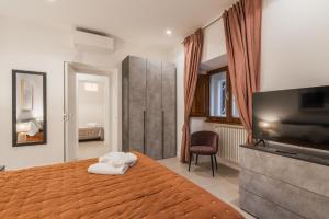 une chambre avec un lit et une télévision à écran plat dans l'établissement The Best in Rome Orologio, à Rome